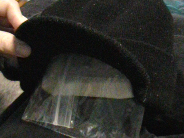 I used a black beenie to keep the bag in.  It provides darkness and warmth.